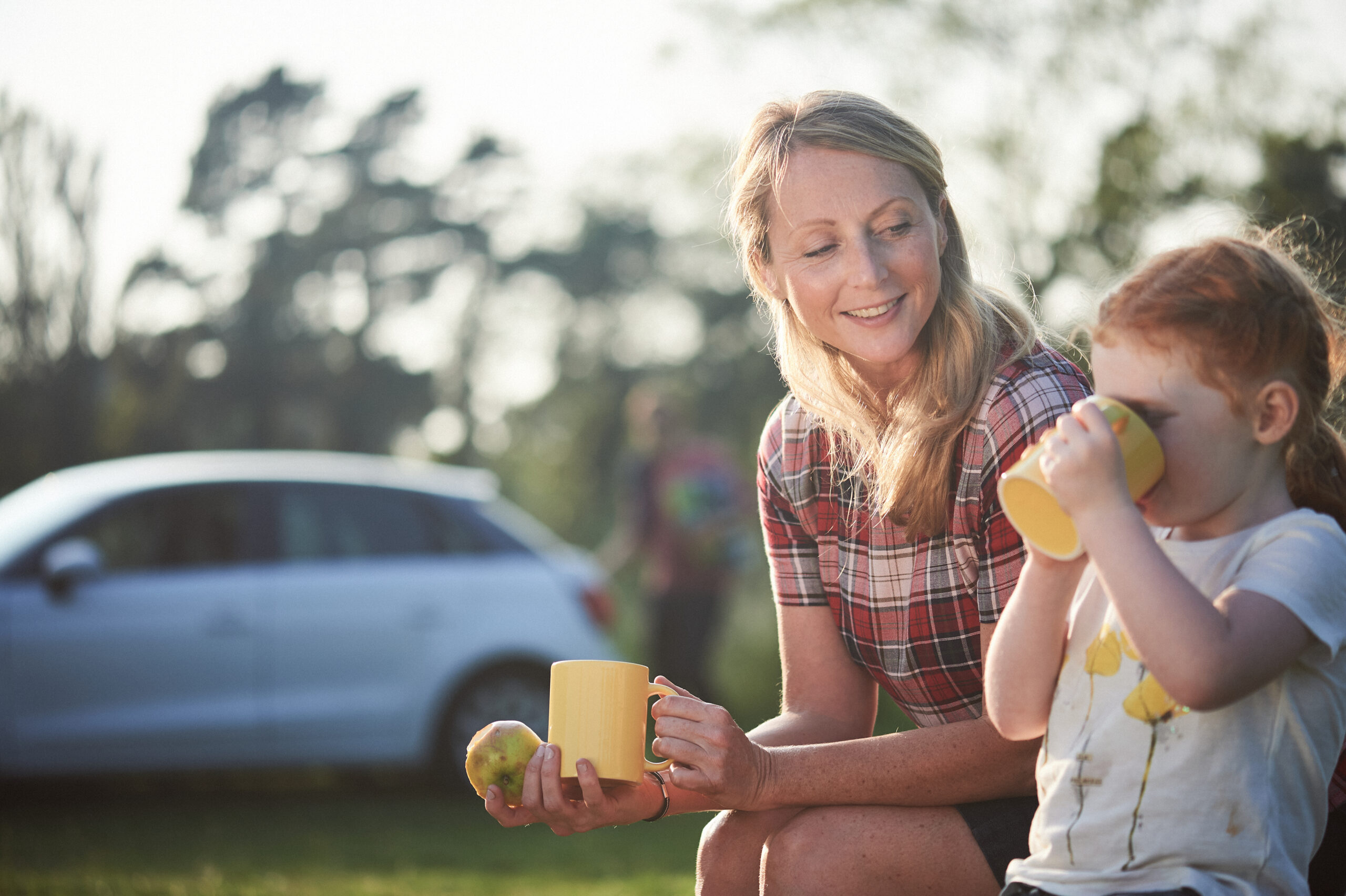 Woman and child sat eating and drinking